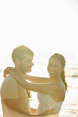 Buy stock photo Shot of a romantic young couple smiling with ocean in the background