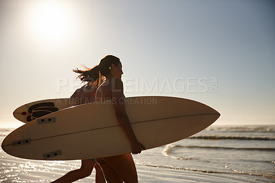 Buy stock photo Shot of a young surfing couple running out to the waves
