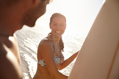 Buy stock photo Portrait shot of a happy young woman smiling with her boyfriend and their surfboards at the beach