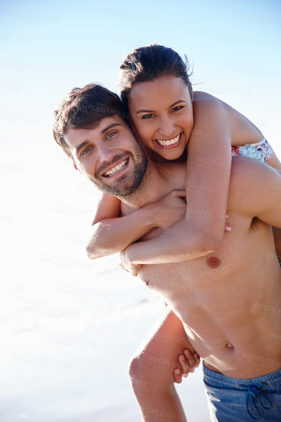 Buy stock photo Portrait, beach and couple piggyback with smile, vacation and travel by sea for romance or affection. Happy man, woman and love with ocean, summer holiday and fun date bonding for honeymoon adventure