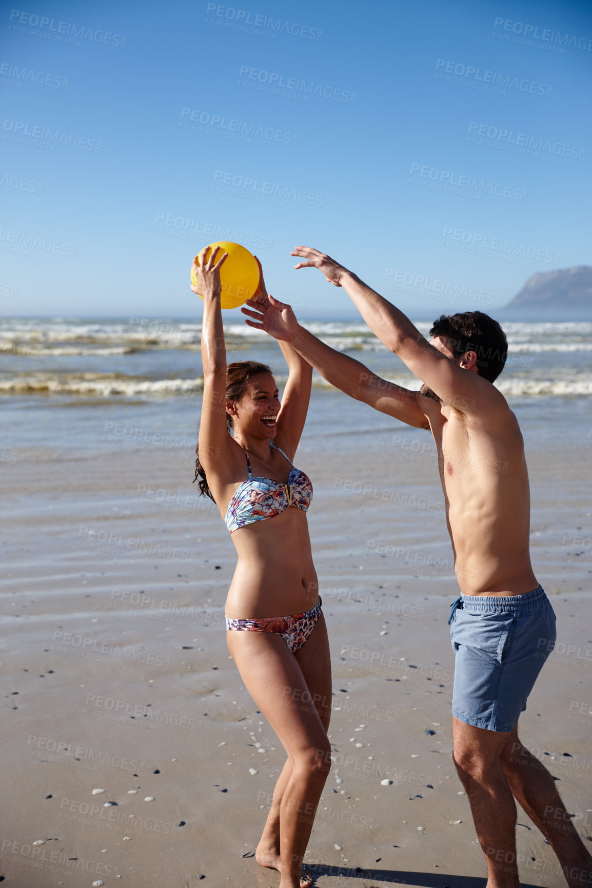Buy stock photo Shot of a happy couple playing with a ball together on a beach