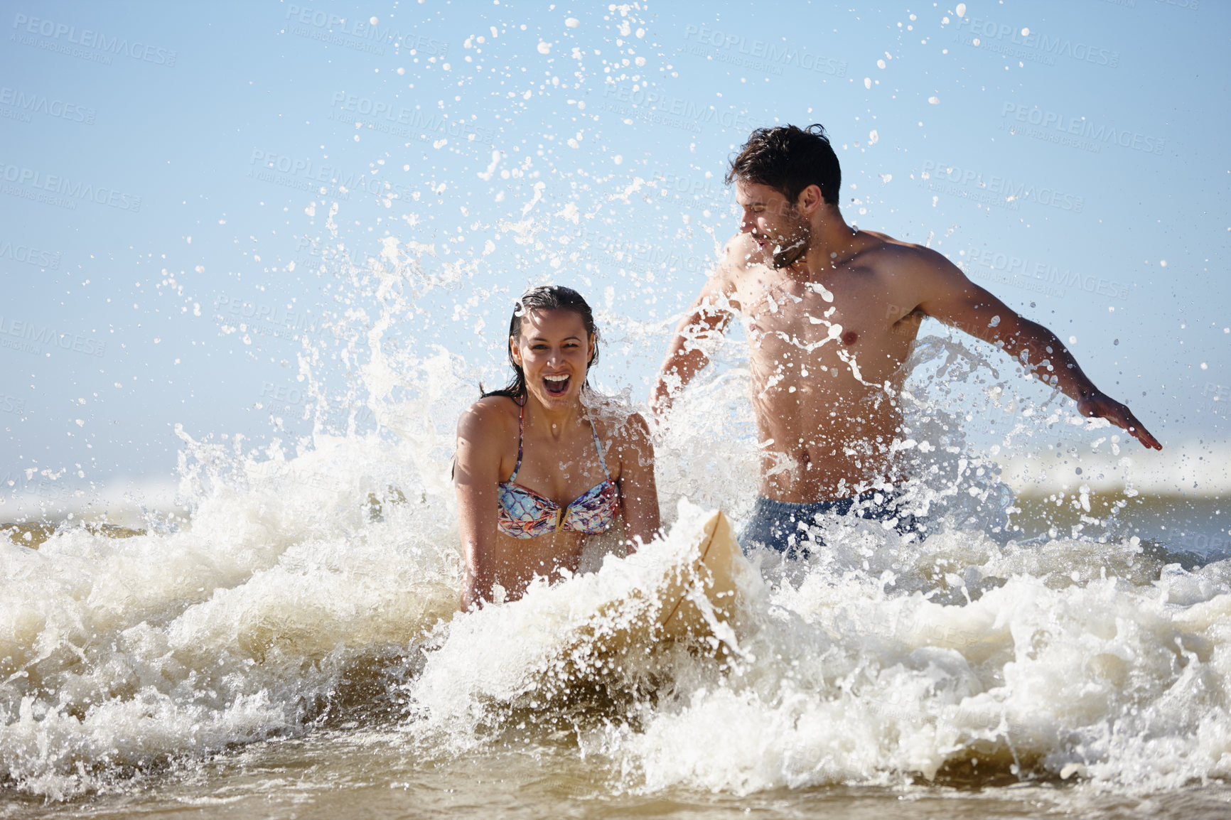 Buy stock photo Shot of a beautiful young woman being given a surfing lesson