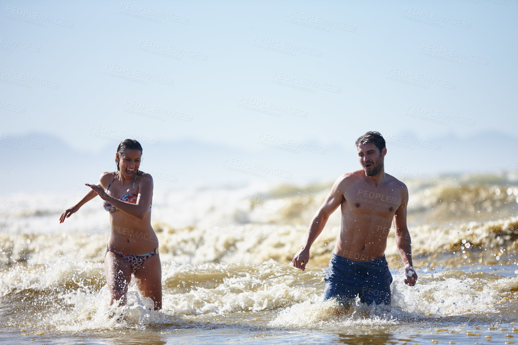 Buy stock photo Beach, play and laughing couple for romance, honeymoon and travel for fun, swim and waves splash. Woman, man and sea on date with partner, adventure and happiness for bonding or joy on holiday