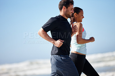 Buy stock photo Cropped shot of a happy young couple enjoying a beach run together