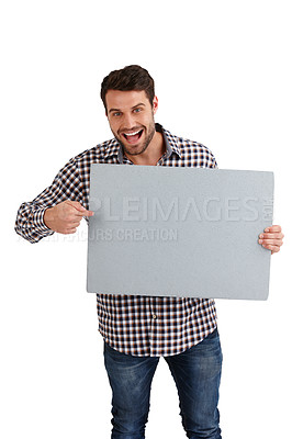 Buy stock photo Studio portrait of a handsome young man pointing to the blank placard he's holding isolated on white