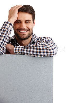 Buy stock photo Studio portrait of a handsome young man leaning on a blank placard isolated on white