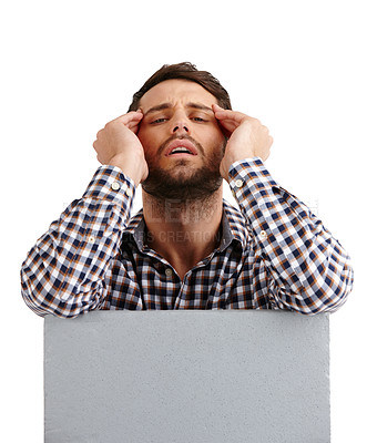 Buy stock photo Studio portrait of a young man looking exhausted while leaning on a blank placard