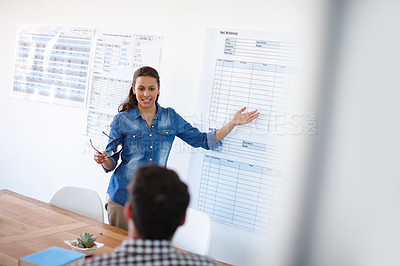 Buy stock photo Cropped shot of an attractive young woman giving a presentation to a male colleague