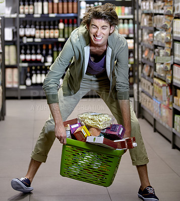 Buy stock photo Supermarket, man and basket with grocery or food, shopping and sale or discount with promotion. Store, male person and pick up groceries form floor, shelf and customer buying or purchasing products