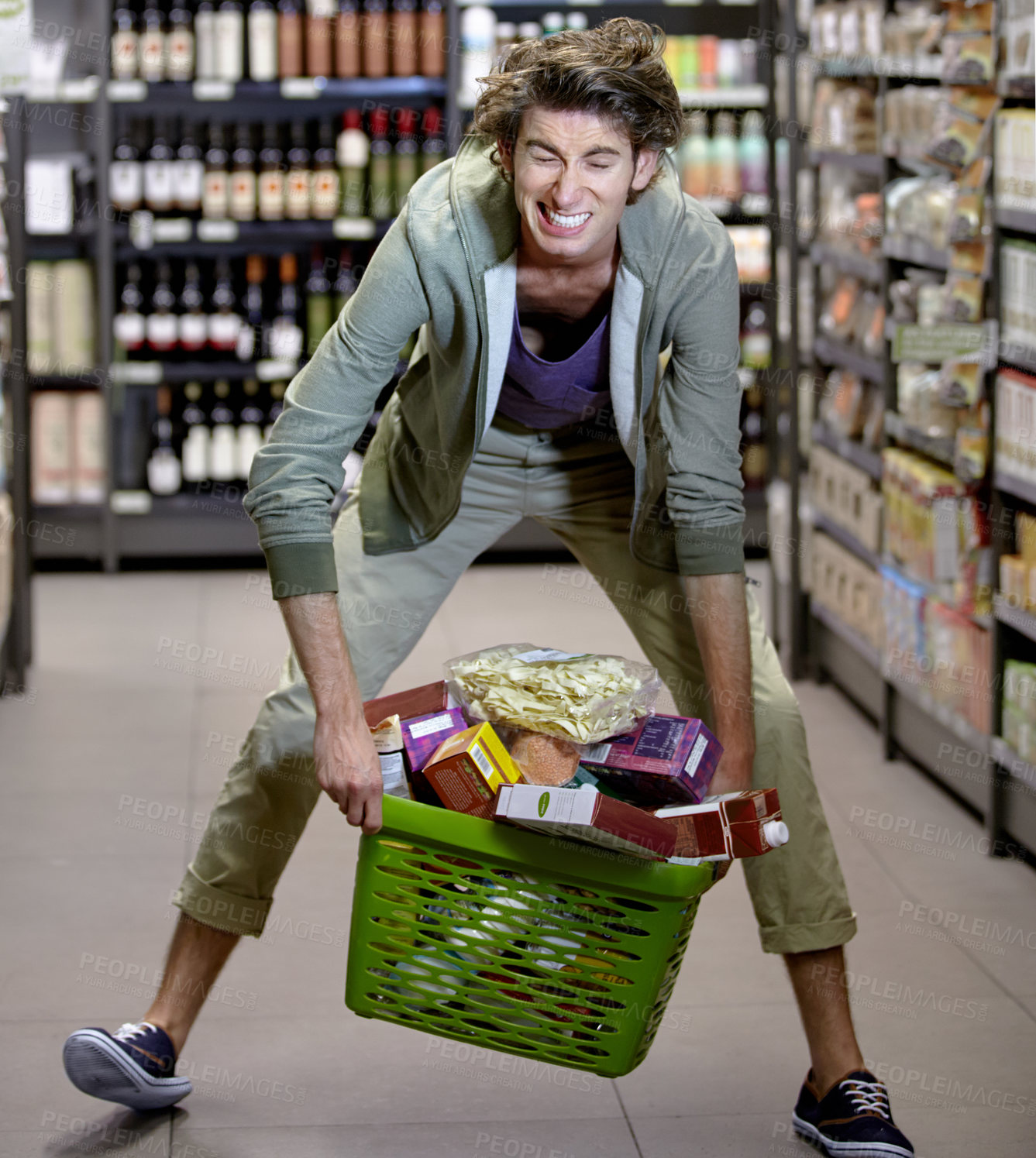 Buy stock photo Supermarket, man and basket with grocery or food, shopping and sale or discount with promotion. Store, male person and pick up groceries form floor, shelf and customer buying or purchasing products