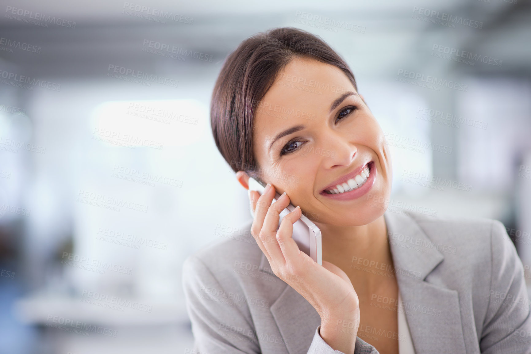 Buy stock photo Shot of a woman using a cellphone while sitting at a desk in an office