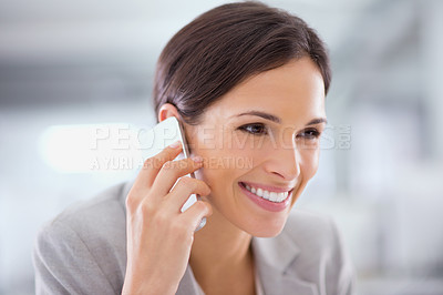 Buy stock photo Shot of a woman using a cellphone while sitting at a desk in an office