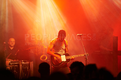 Buy stock photo Shot of a guitarist playing on stage at a concert