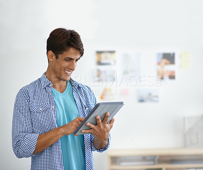 Buy stock photo An ethnic businessman working on his digital tablet - copyspace