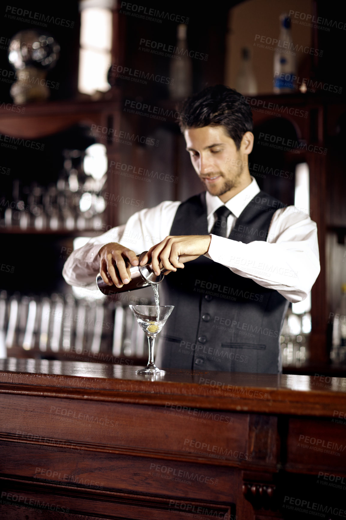 Buy stock photo Bartender man, glass and mixing cocktail at bar for service, drink or hospitality at party, club or event. Male server, barman or waiter with alcohol, spirit or mixer for presentation at restaurant