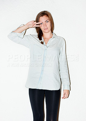 Buy stock photo Fashion, peace sign on eyes and portrait of woman on a white background with confidence, pride and emoji. Serious, hand sign and isolated person in trendy clothes, casual outfit or style in studio