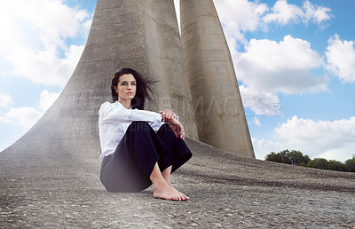 Buy stock photo Fashion, woman and thinking outdoors for idea, memory and mindfulness by concrete structure. Vision, wind and barefoot girl on ground for calm, reflecting and meditation in city by solid monument