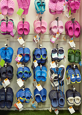Buy stock photo Shot of children's shoes hanging on a rack in a stor