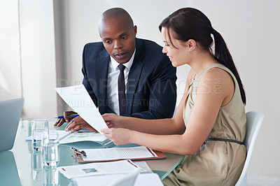 Buy stock photo Cropped shot of two business colleagues discussing documents in a meeting