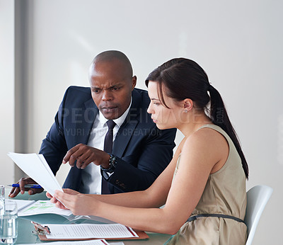 Buy stock photo Cropped shot of two business colleagues discussing documents in a meeting