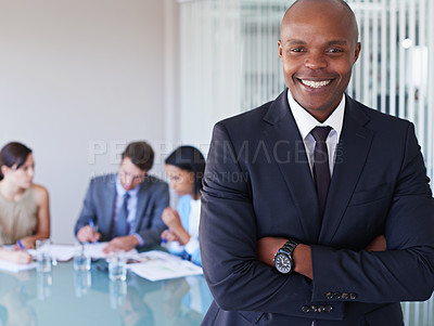 Buy stock photo Portrait of a handsome businessman with his colleagues working in the background
