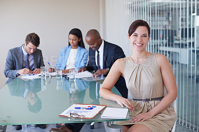 Buy stock photo Portrait of a confident businesswoman with her colleagues having a discussion in the background