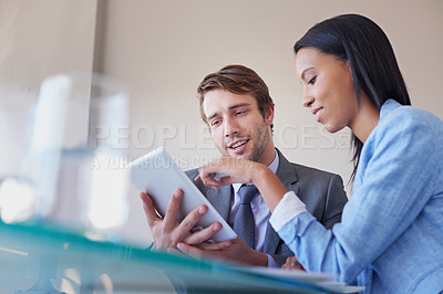 Buy stock photo Cropped shot of two business executives discussing work on a digital tablet