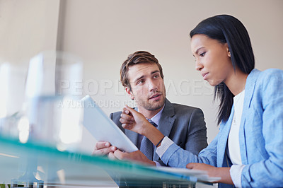 Buy stock photo Cropped shot of two business executives discussing work on a digital tablet