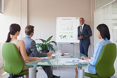 Buy stock photo Shot of a business manager presenting financial data to his colleagues during a meeting