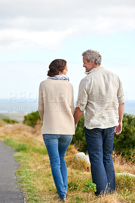 Buy stock photo Old couple, walking and holding hands in nature on holiday, vacation or retirement with support. Back, man and woman with love, care and happiness in marriage together on a road, journey or path 