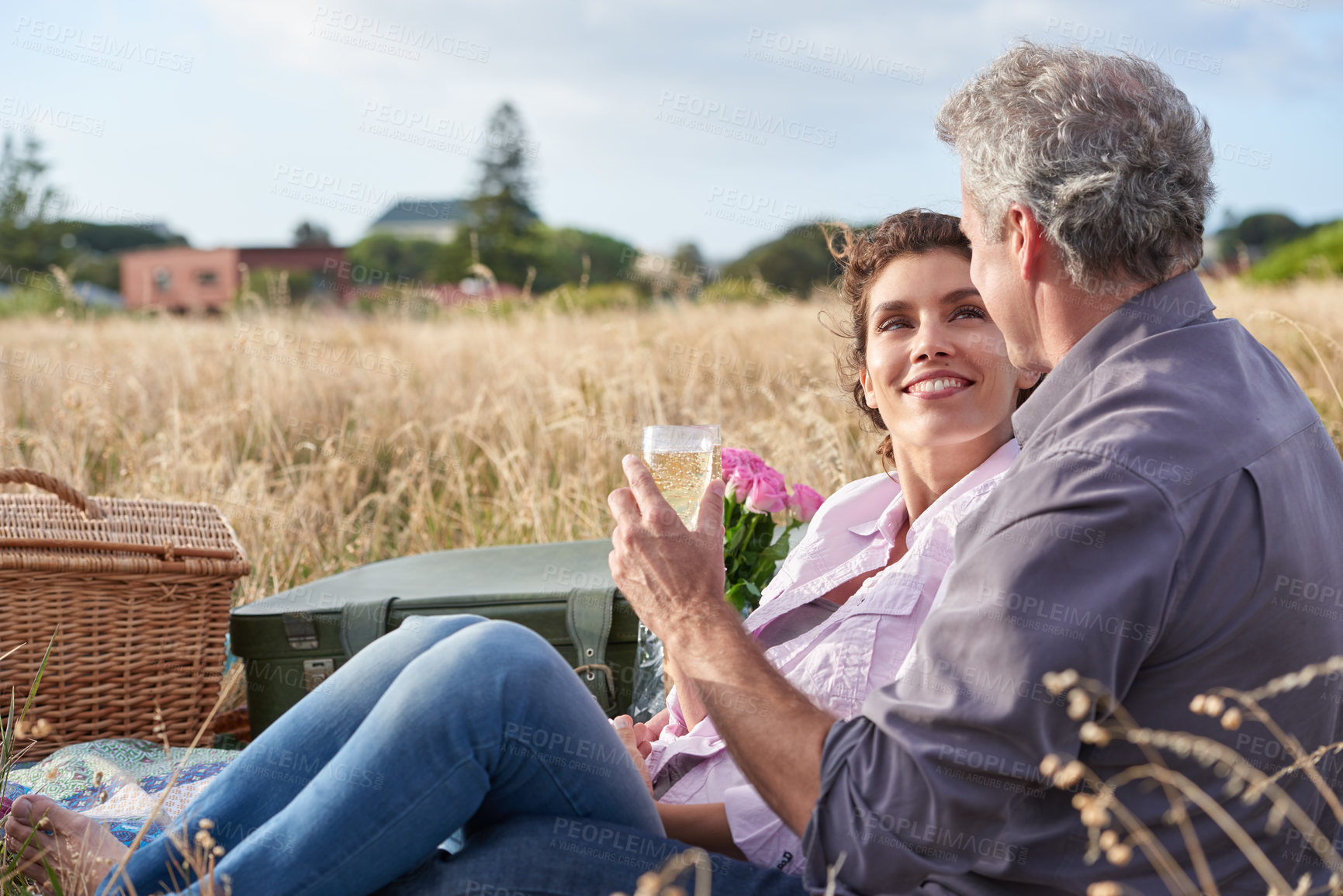 Buy stock photo Mature, couple relax and picnic in park on date with love, care or support in marriage. Outdoor, man and woman on grass in nature with drink, flowers or celebration in summer, holiday or vacation