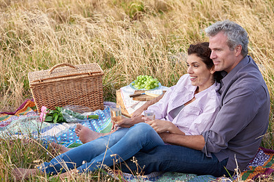 Buy stock photo Happy, senior couple and picnic in park, grass and basket in nature for a date or celebration with love or care. Mature, woman and man in field in summer, holiday or vacation with food and drinks