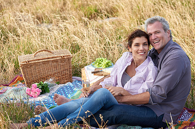Buy stock photo Old couple, relax and portrait of picnic in park for a date with love, care or support in marriage. Happy, man and woman on grass with food, flowers and celebration in retirement, holiday or vacation