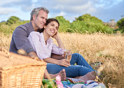 Buy stock photo Senior couple, relax and picnic in park, grass and basket in nature for a date in retirement with love or care. Mature, woman and man in field in summer, holiday or vacation with freedom and drinks