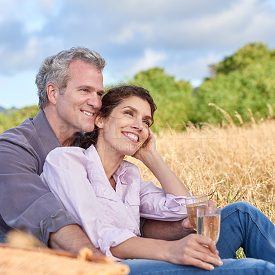 Buy stock photo Senior couple, relax and picnic in park, grass and drink in nature for a date in retirement with love or care. Mature, woman and man in field in summer, holiday or vacation with freedom and wine