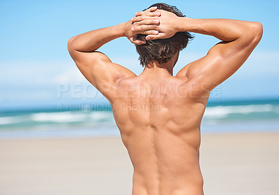 Buy stock photo Rear view of an attractive young man looking out at the ocean