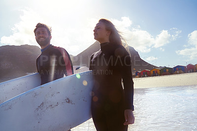 Buy stock photo Shot of an athletic young couple surfing at their favourite beach