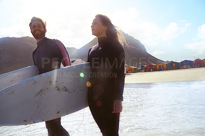 Buy stock photo Shot of an athletic young couple surfing at their favourite beach