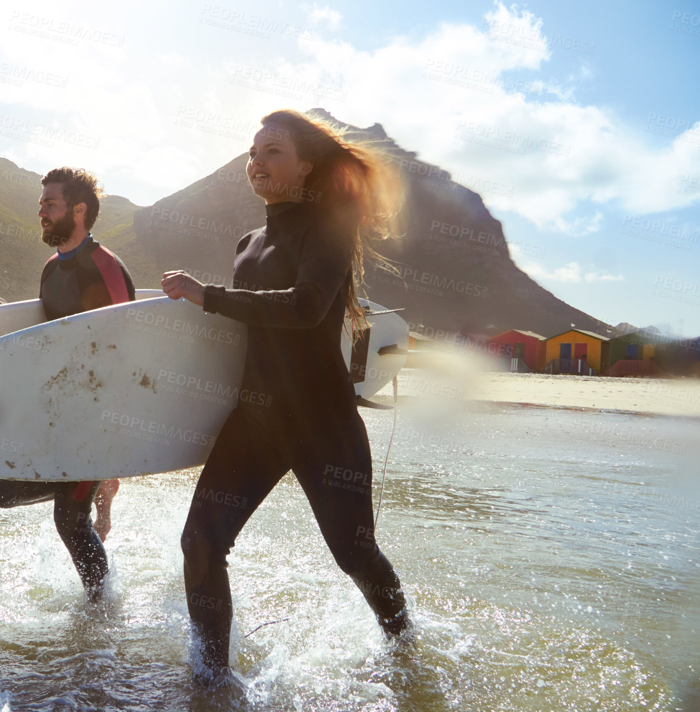 Buy stock photo Shot of an athletic young couple surfing at their favourite beach