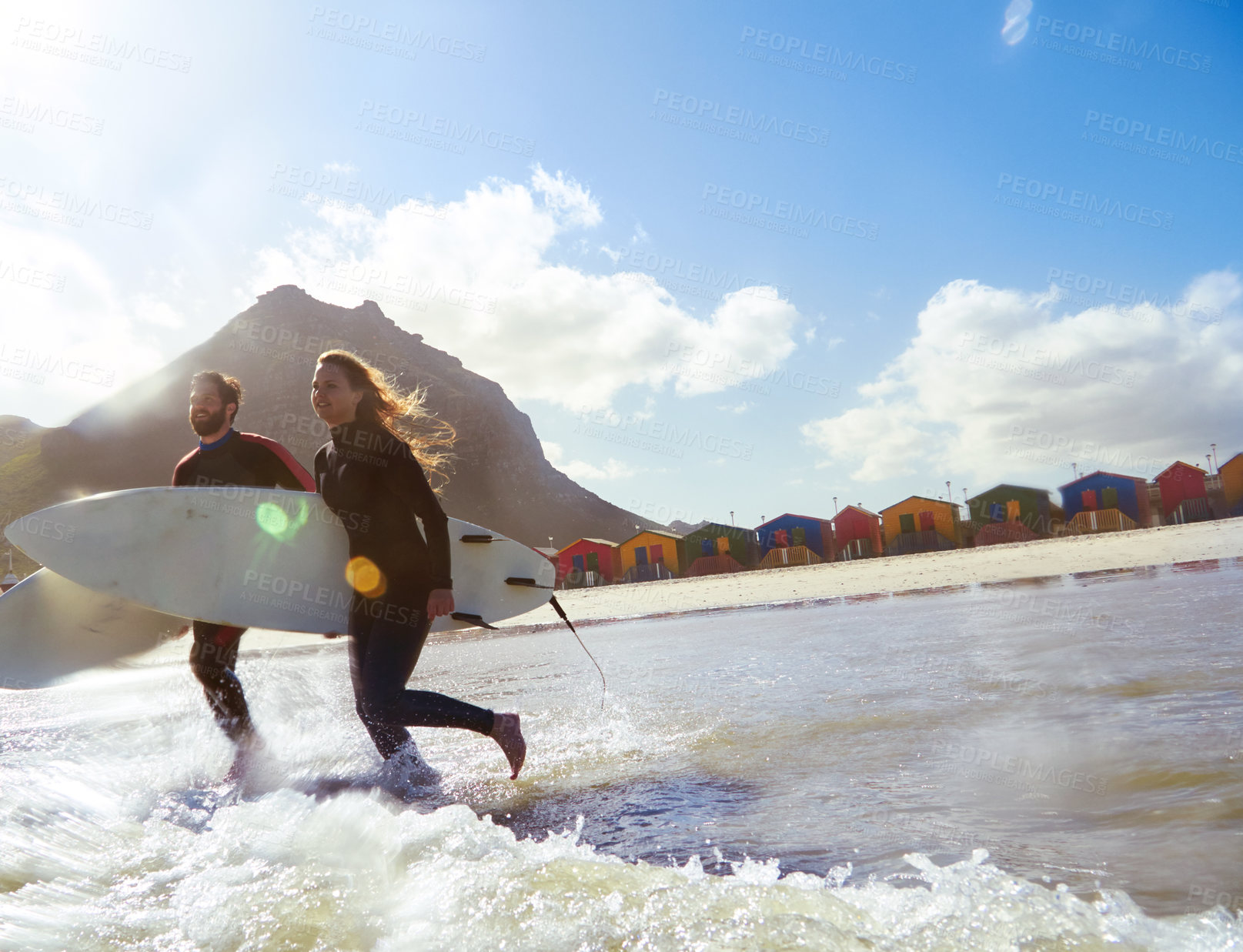 Buy stock photo Shot of an athletic young couple surfing at their favourite beach