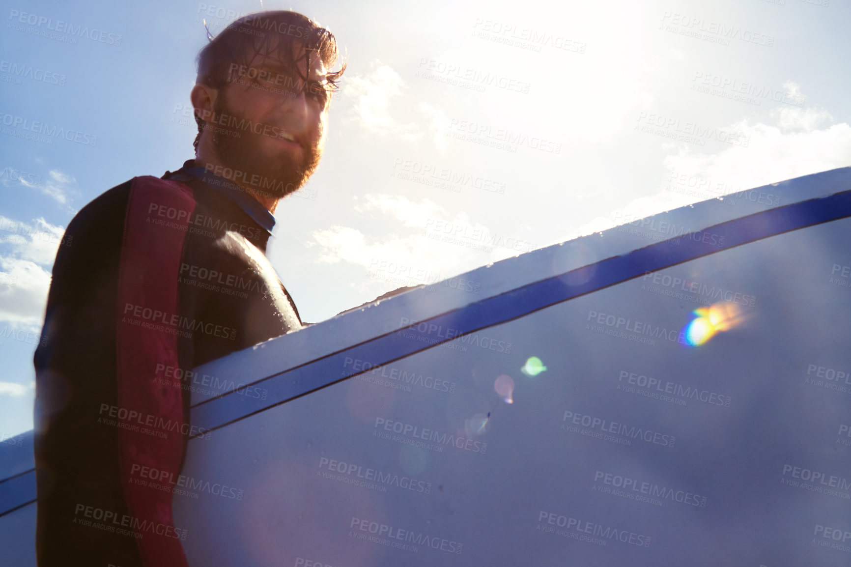 Buy stock photo Shot of a young male surfer carrying his surfboard at the beach