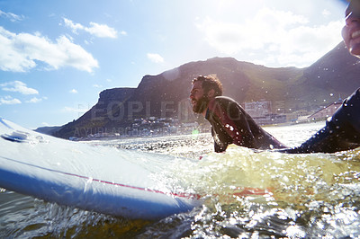 Buy stock photo Shot of a young couple surfing waves together