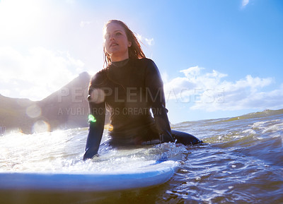 Buy stock photo Shot of a young woman on her surfboard in the sea