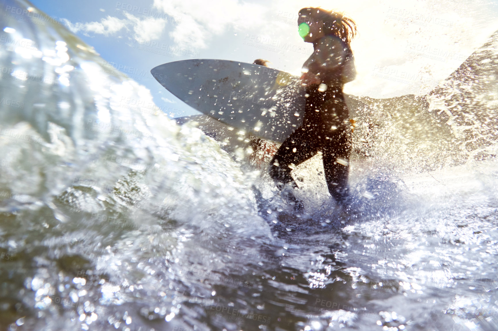 Buy stock photo Shot of a female surfer walking into the waves with her surfboard