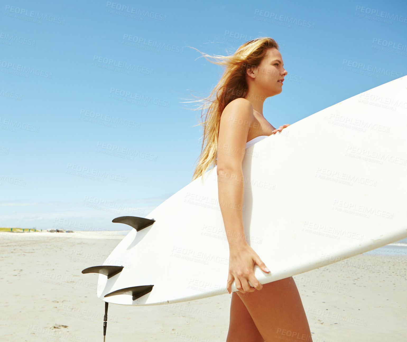 Buy stock photo Shot of a young female surfer carrying her surfboard on the beach