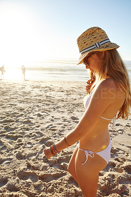 Buy stock photo Shot of an attractive young woman in a bikini enjoying a day at the beach