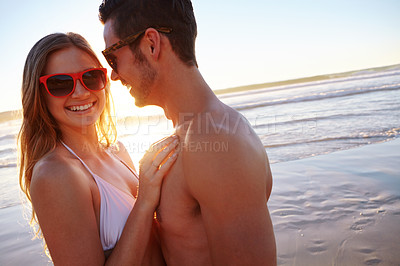 Buy stock photo Shot of a young couple enjoying a romantic moment at the beach