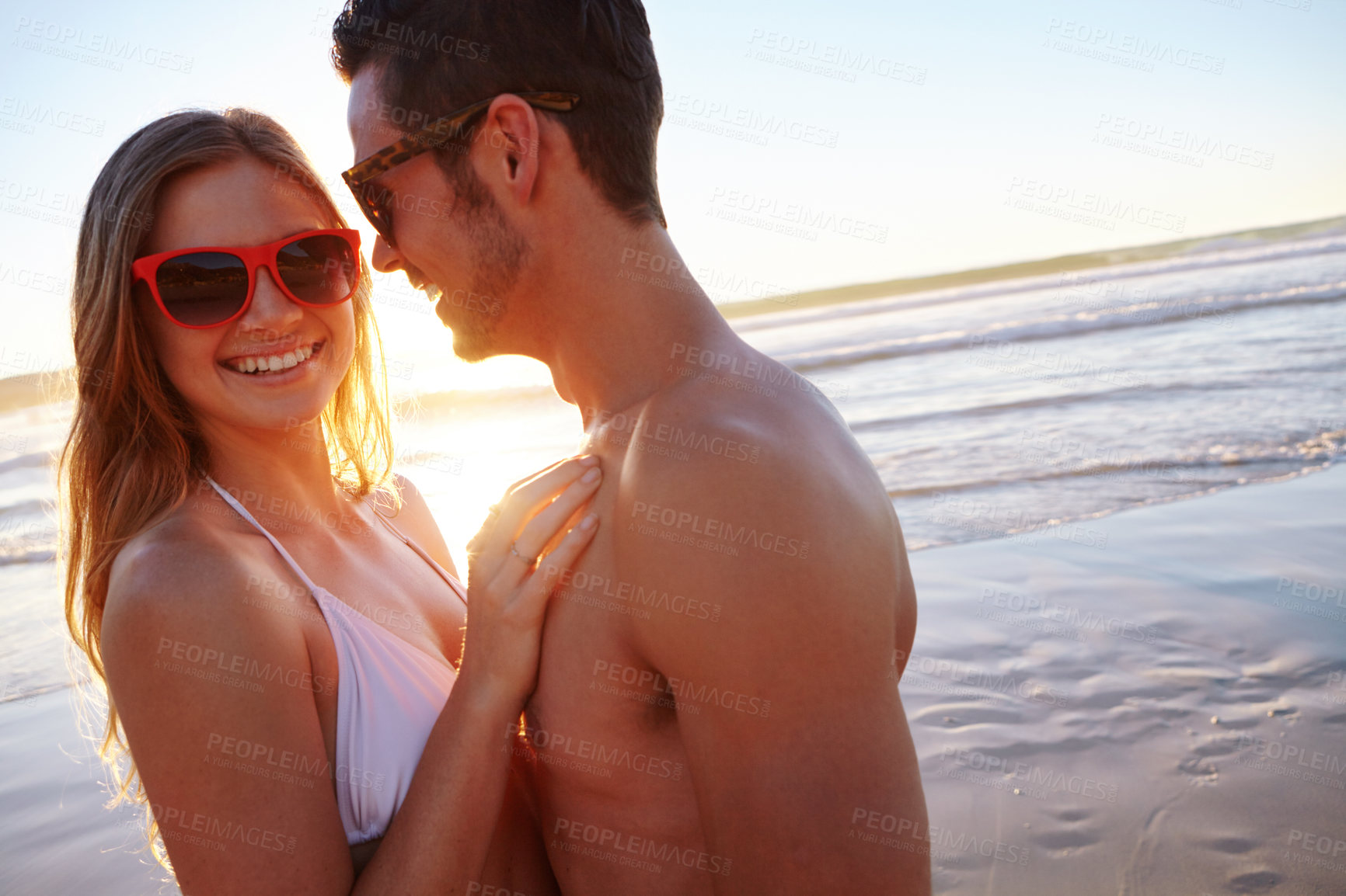 Buy stock photo Shot of a young couple enjoying a romantic moment at the beach