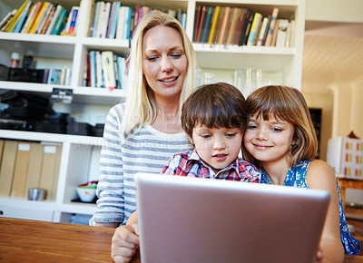 Buy stock photo Shot of a young brother and sister using a digital tablet together while their mother looks on