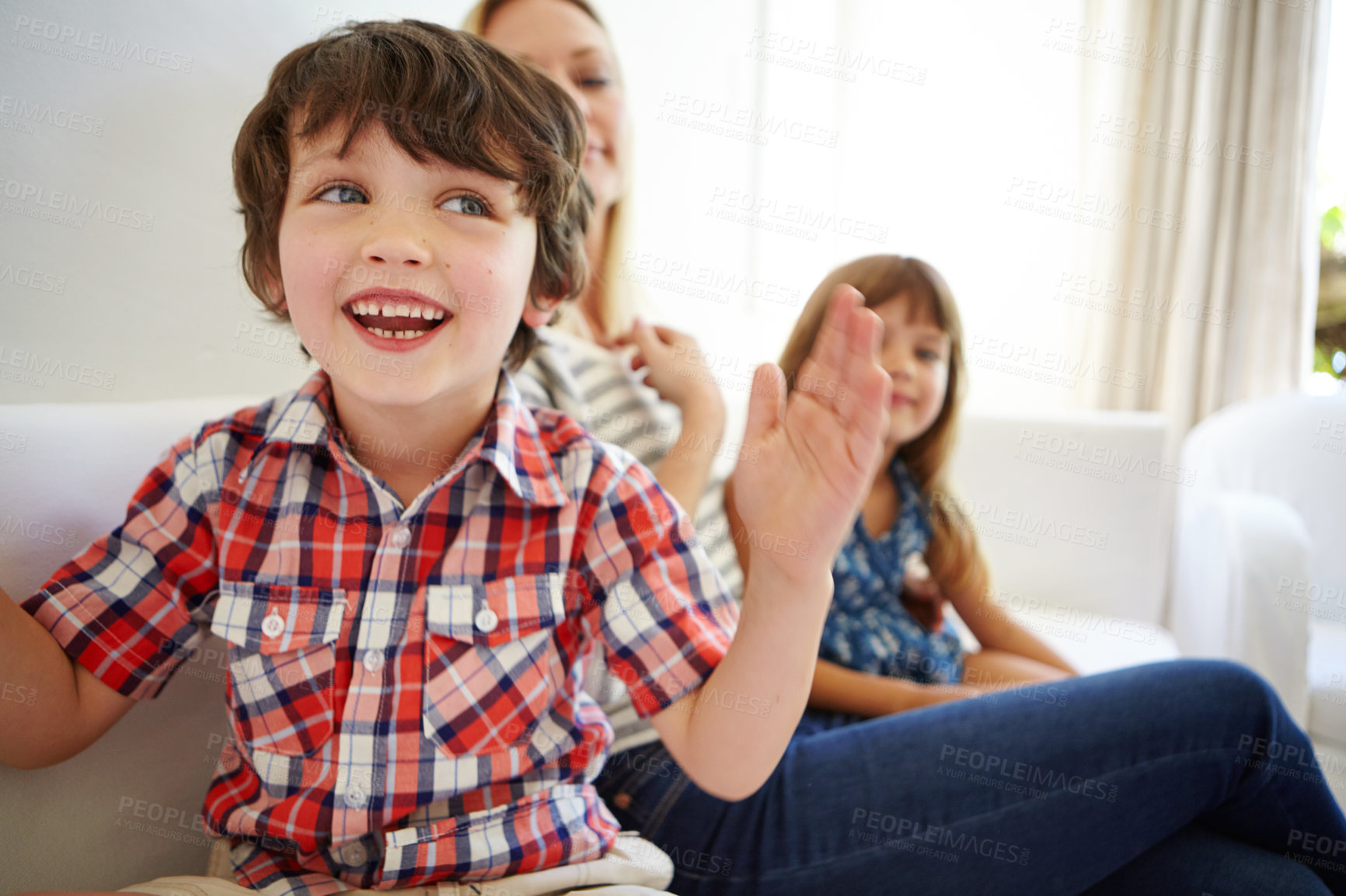 Buy stock photo Shot of a happy family spending quality time together at home on the sofa